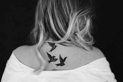 Close-up portrait of woman against black background