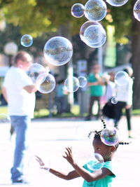 Low section of boy playing with bubbles