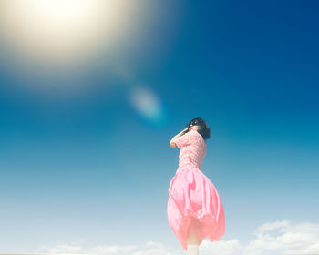 Rear view of woman against blue sky