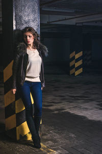 Beautiful woman standing against column in parking garage