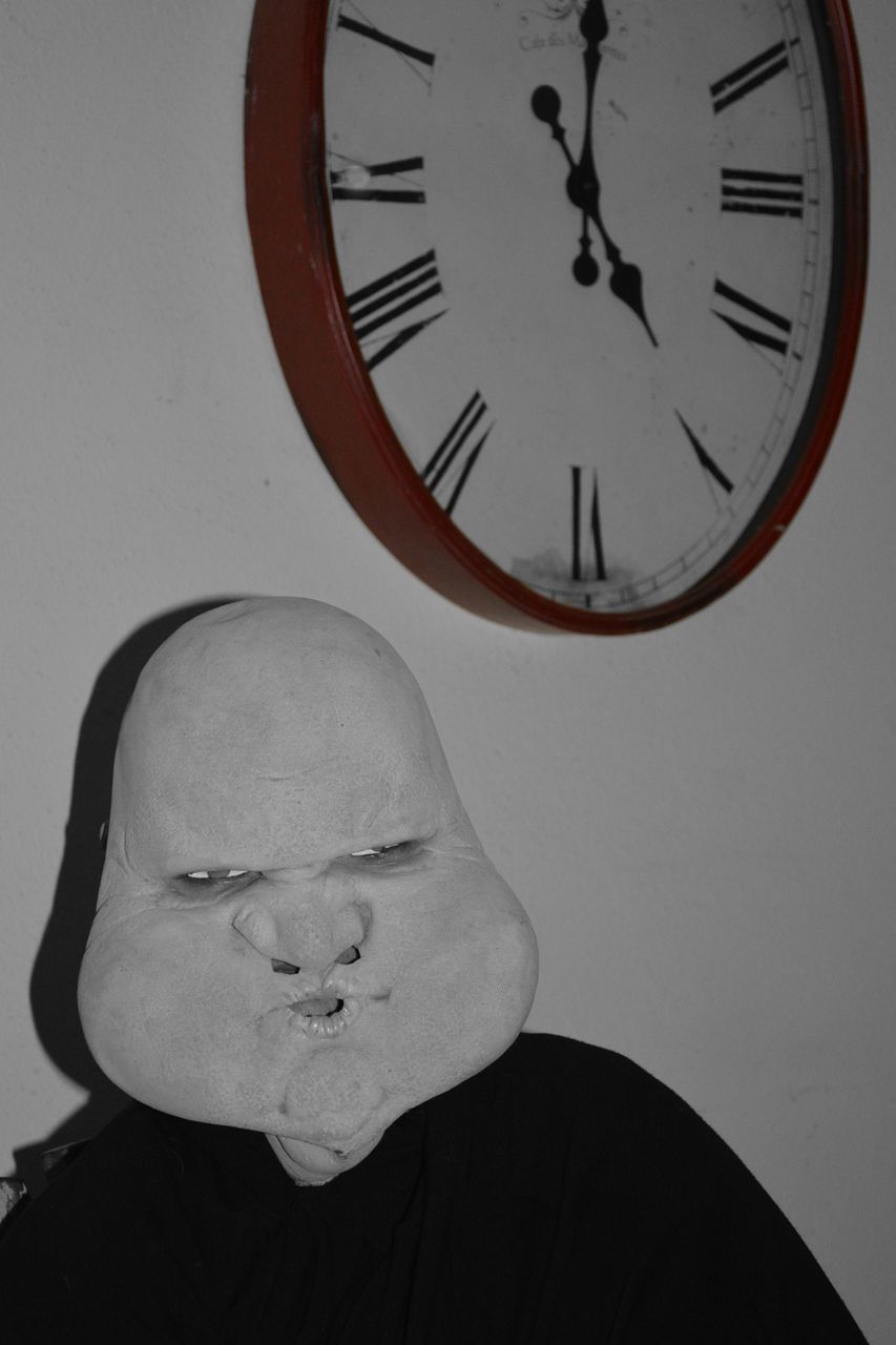 PORTRAIT OF MAN AGAINST WALL CLOCK