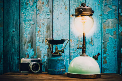 Close-up of illuminated light bulb on table against wall