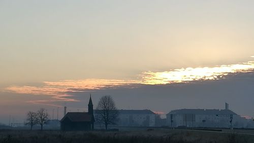 Silhouette buildings against sky during sunset