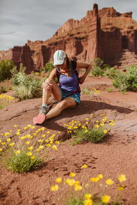 Female hiker laughs as she sits for a water break in utah desert