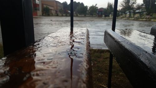 Close-up of wet footpath by river during rainy season