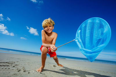 Full length of girl playing at beach