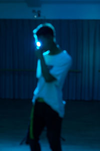Man standing by illuminated light