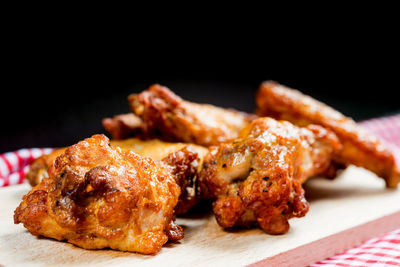 Close-up of barbecue meat on cutting board against black background