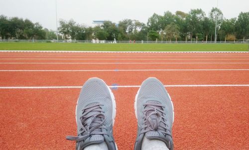 Low section of person wearing shoes on running track