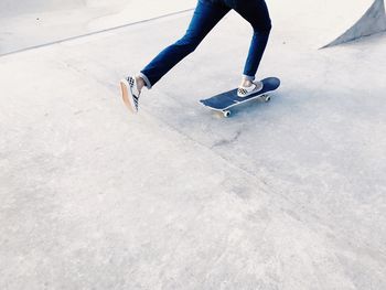 Low section of woman skateboarding on skateboard
