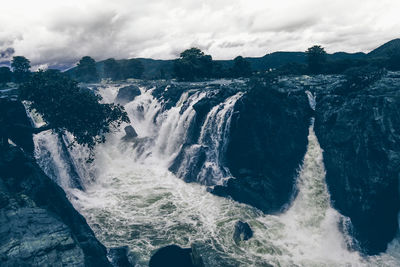 Scenic view of waterfall against sky