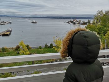 Rear view of people looking at sea against sky