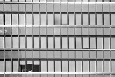 Three open windows in an otherwise shut office building in madrid, spain