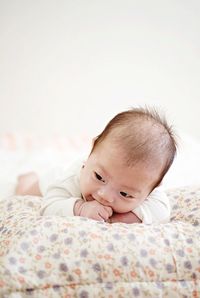 Portrait of cute baby lying on bed