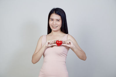 Portrait of a smiling young woman over white background