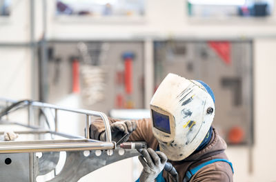 Rear view of man working in factory