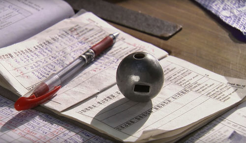 Paperweight and pen on book at table