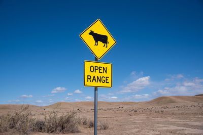 Information sign on road against sky open range sign