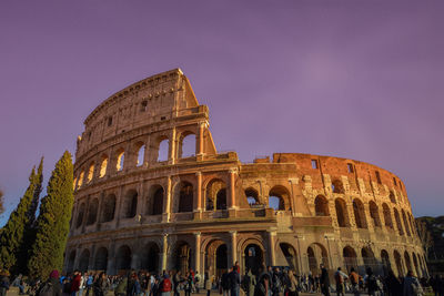 People at historical building against sky