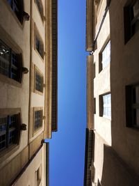 Low angle view of buildings against clear blue sky