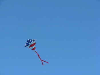 Low angle view of kite against clear blue sky