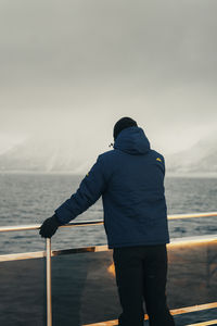 Rear view of man standing against sky during sunset