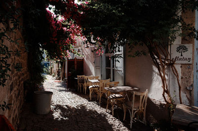 Empty chairs and tables against building