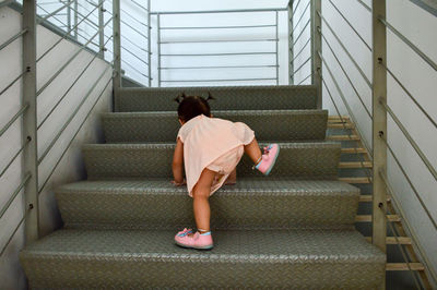 Rear view of woman on staircase