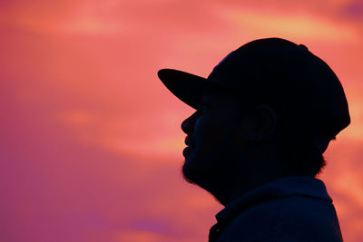 Portrait of silhouette boy looking away against sky during sunset