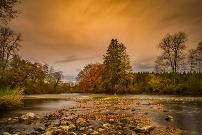 Scenic view of river against sky at sunset