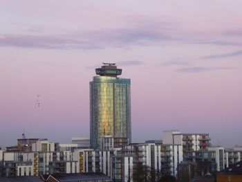 Buildings in city against cloudy sky