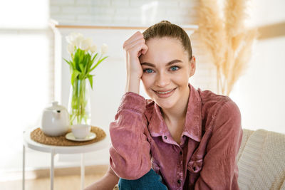 Calm young caucasian woman sitting on a comfortable chair and enjoying