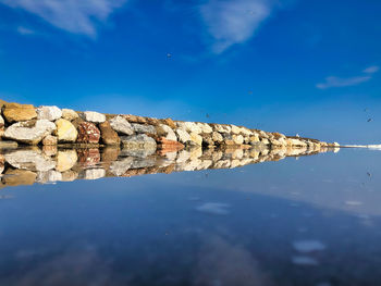 Reflection of clouds in water against blue sky