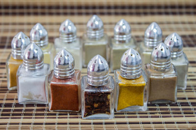 Close-up of spices arranged in glass containers on mat