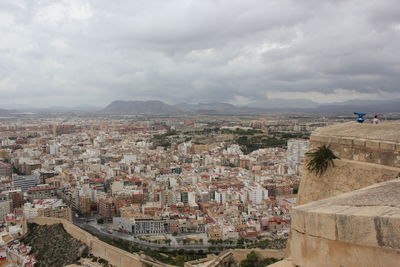 High angle view of buildings in city against cloudy sky