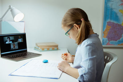 Side view of girl doing homework at home