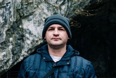 Portrait of man standing against cave