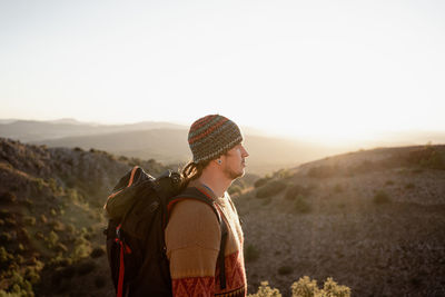 Man looking at mountains against clear sky