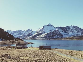 Scenic view of lake and mountains against clear blue sky