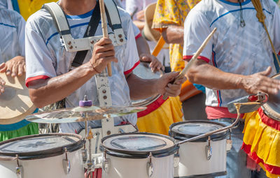 Midsection of man playing drum