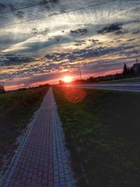 Empty road against sky during sunset