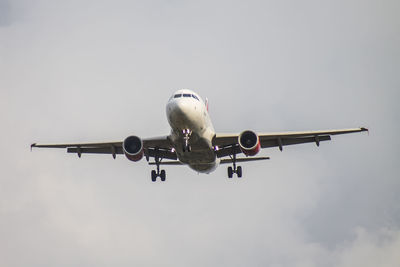 Low angle view of airplane flying against sky