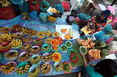 High angle view of woman buying vegetable from female vendor at market