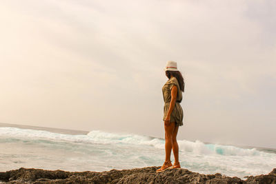 Man standing at beach against sky