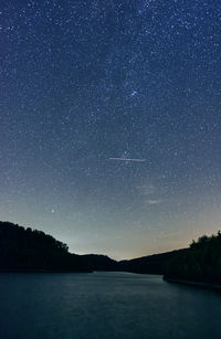 Scenic view of lake against sky at night