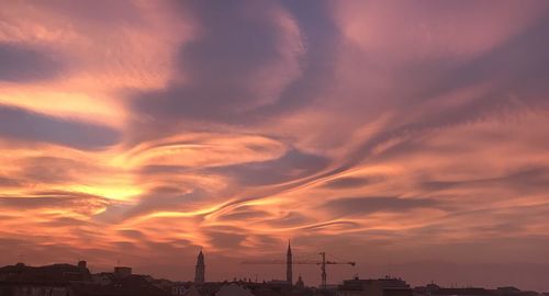 Low angle view of silhouette buildings against dramatic sky