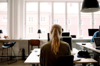 Rear view of businesswoman working in creative office