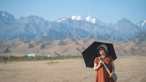 Portrait of woman standing against mountain