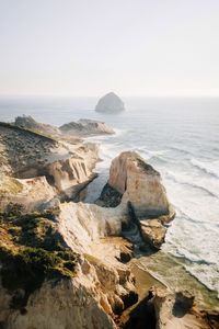 Rock formations on shore against clear sky