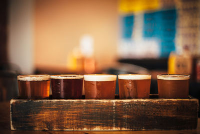 Close-up of beer served in wooden tray at bar